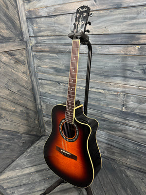 Acoustic guitar leaning against a wooden wall