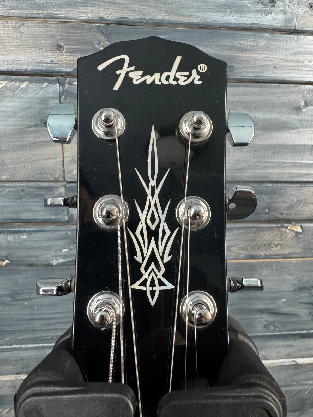 Fender guitar headstock with logo against a wooden background