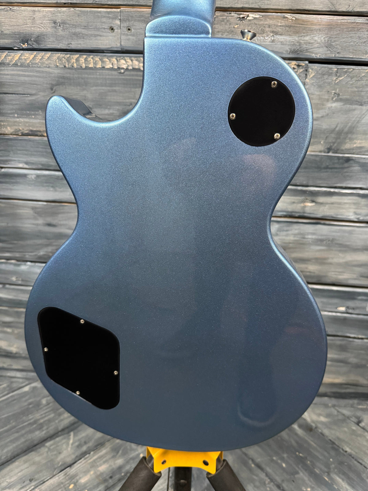 Blue electric guitar body on a wooden surface