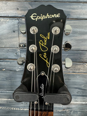 Guitar headstock with 'Epiphone' branding against a wooden background