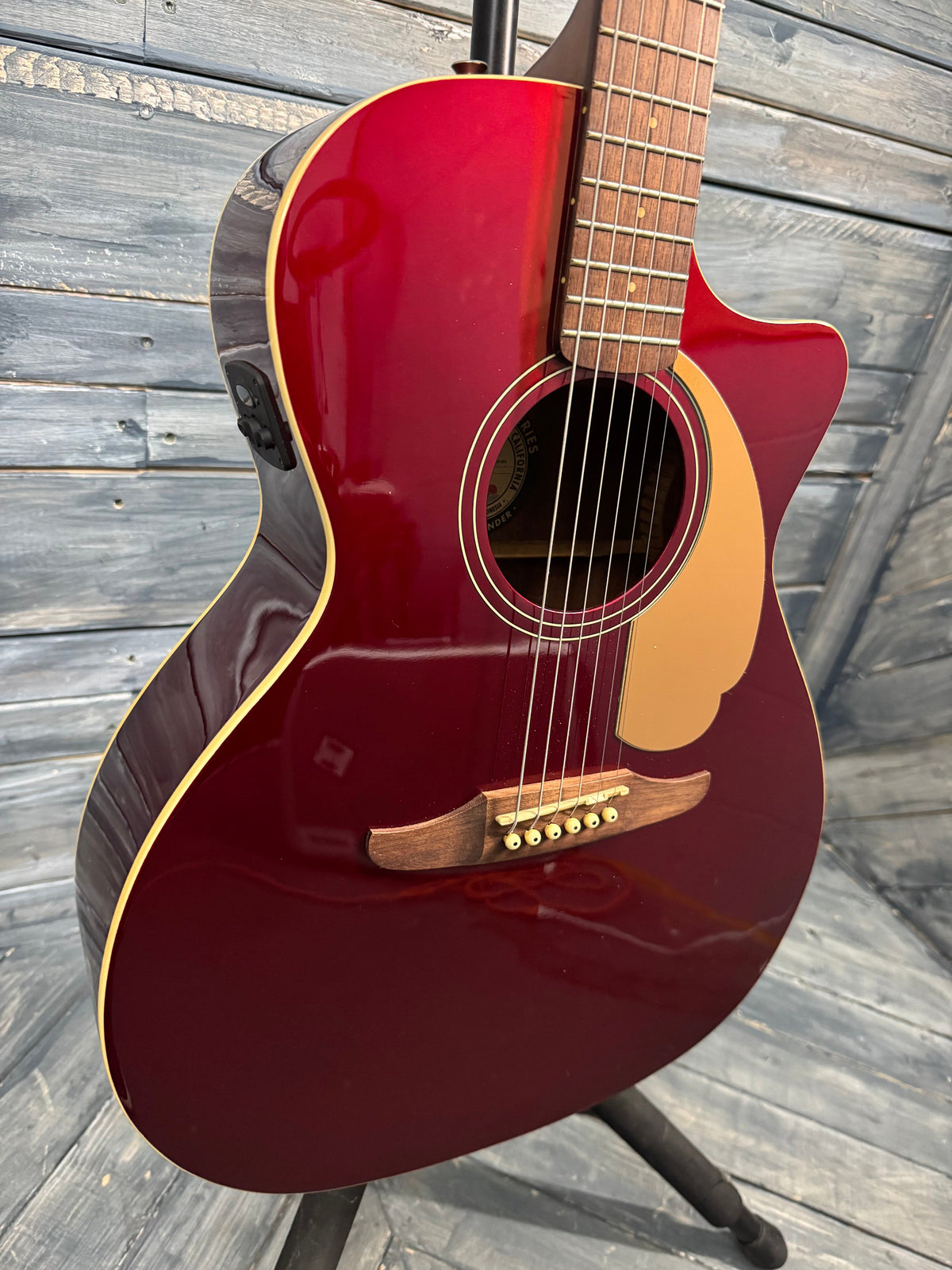 Red acoustic guitar on a wooden deck