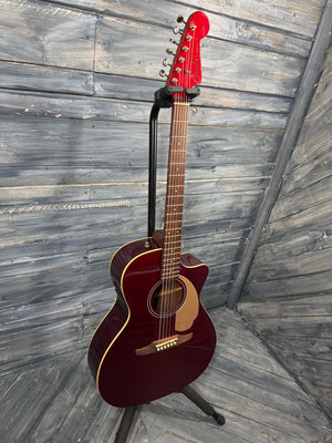 Acoustic guitar on a stand against a wooden background