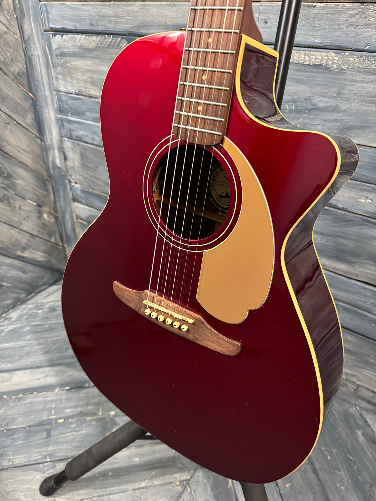 Red acoustic guitar on a wooden surface