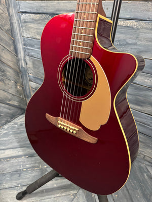 Red acoustic guitar on a wooden surface