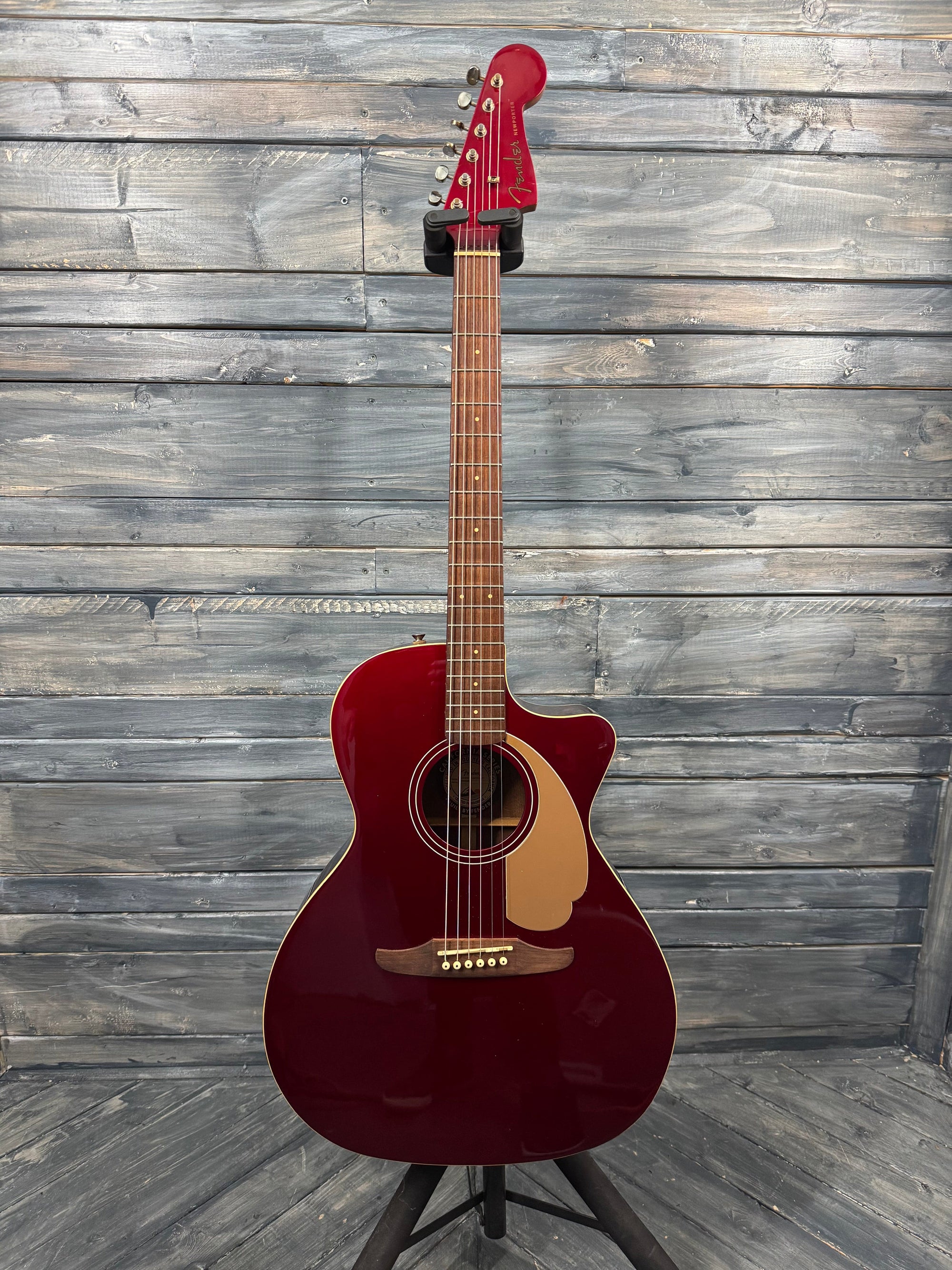 Acoustic guitar with a red finish on a wooden background