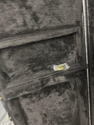 Black guitar case with a small yellow object inside