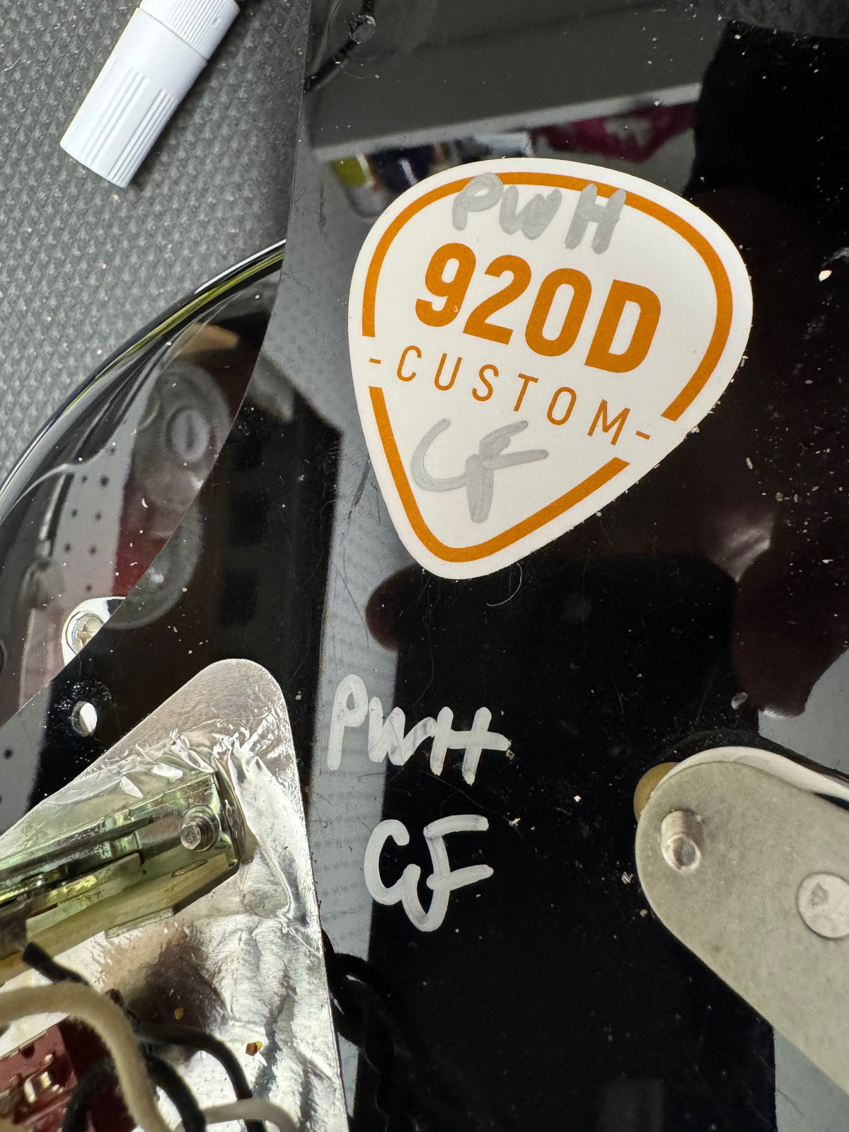 Close-up of a 'PWH 920D Custom' sticker on a reflective surface.