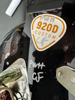 Close-up of a 'PWH 920D Custom' sticker on a reflective surface.