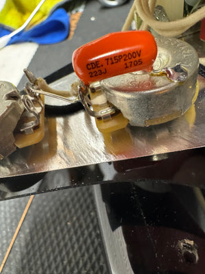 Electrical component with a red capacitor on a metallic surface