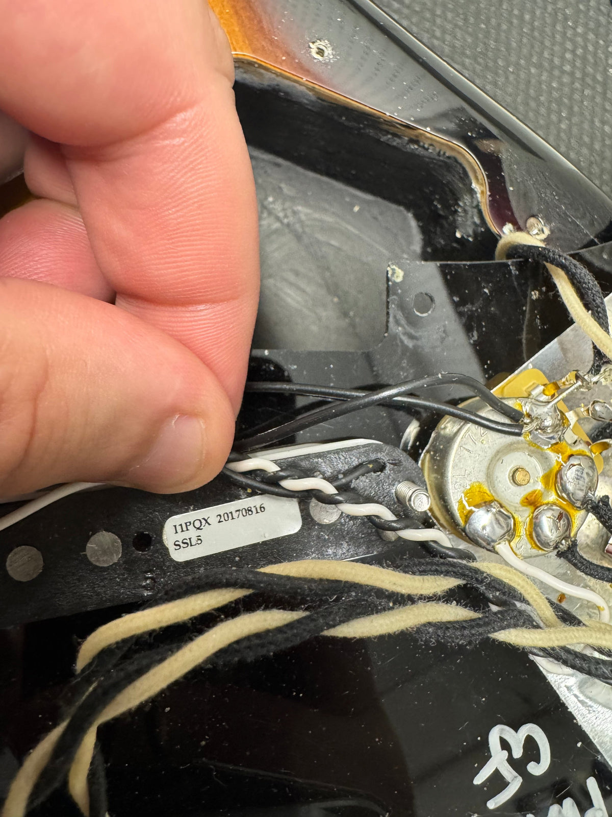 Close-up of a hand working on electronic components with visible branding.