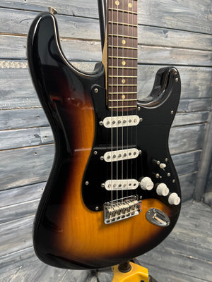 Electric guitar with a sunburst finish on a wooden surface