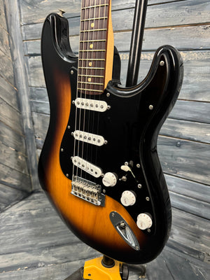 Fender Stratocaster guitar with a sunburst finish on a wooden surface