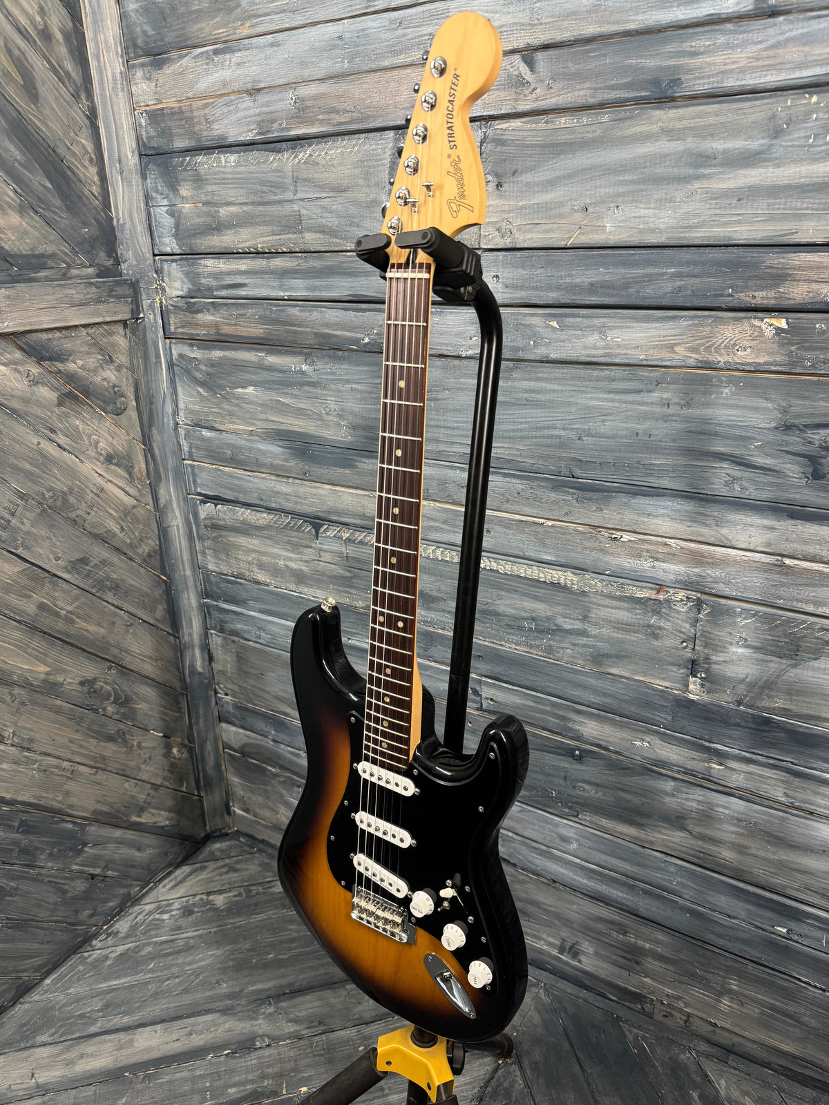 Electric guitar with a sunburst finish against a wooden background