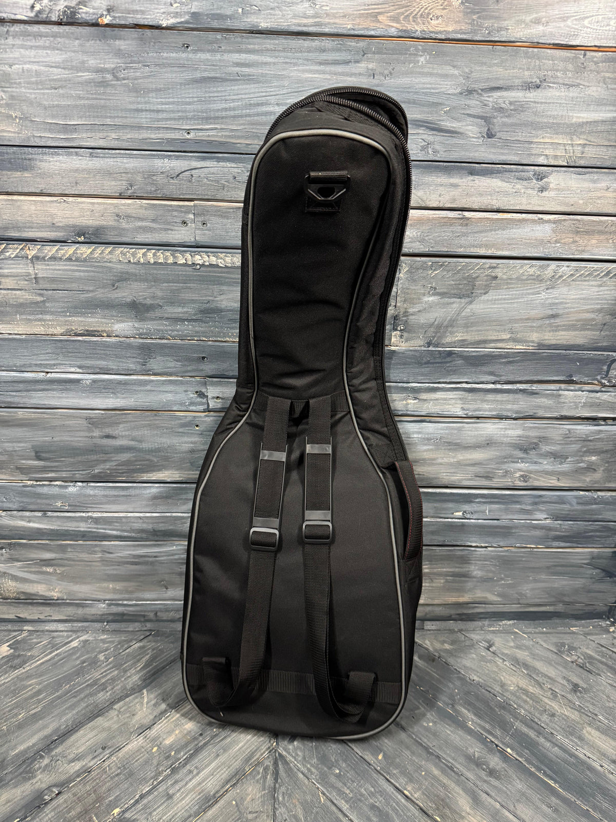 Black guitar case on a wooden floor
