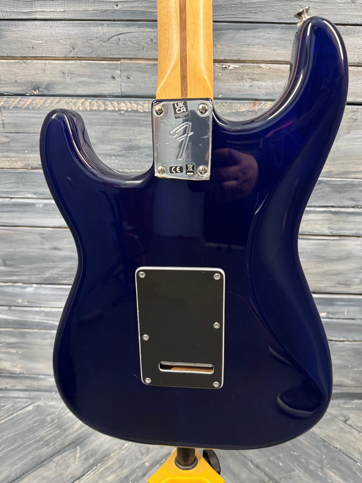 Blue electric guitar body with Fender logo on a wooden surface
