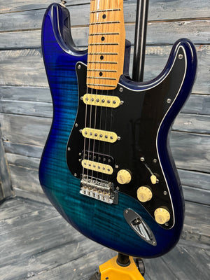 Blue electric guitar with a wooden neck against a wooden background