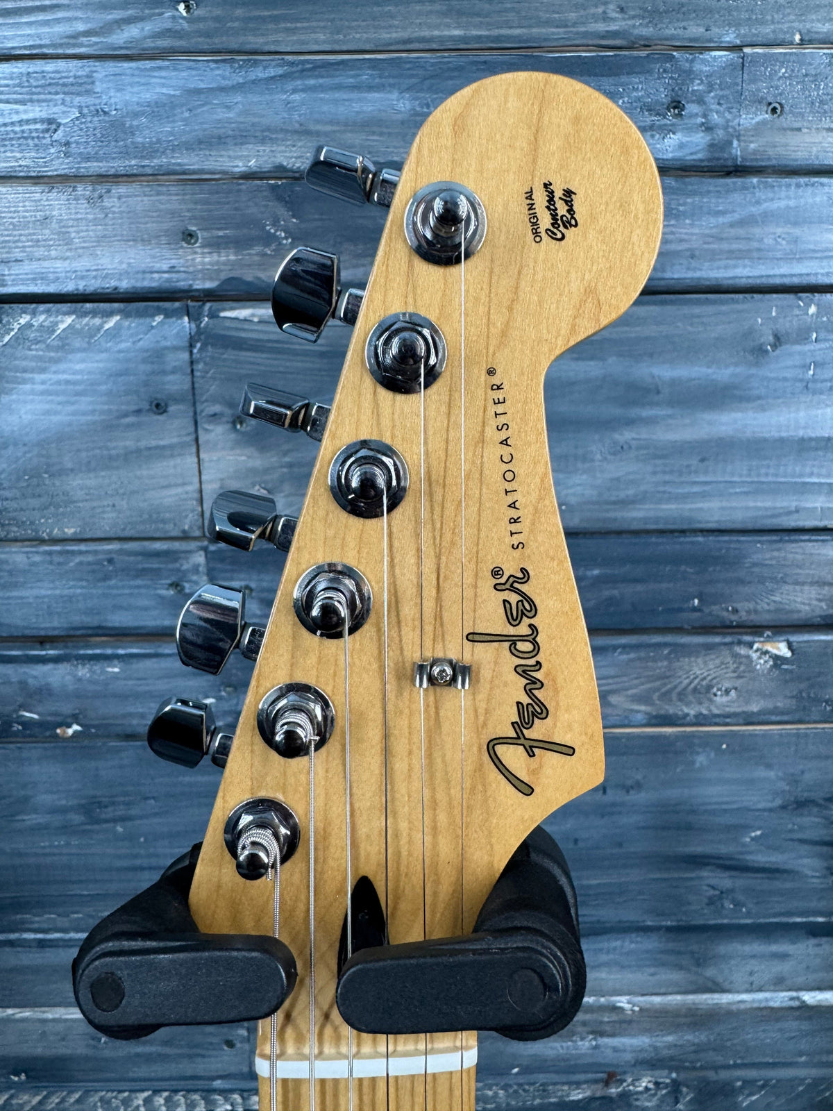 Fender guitar headstock on a wooden background