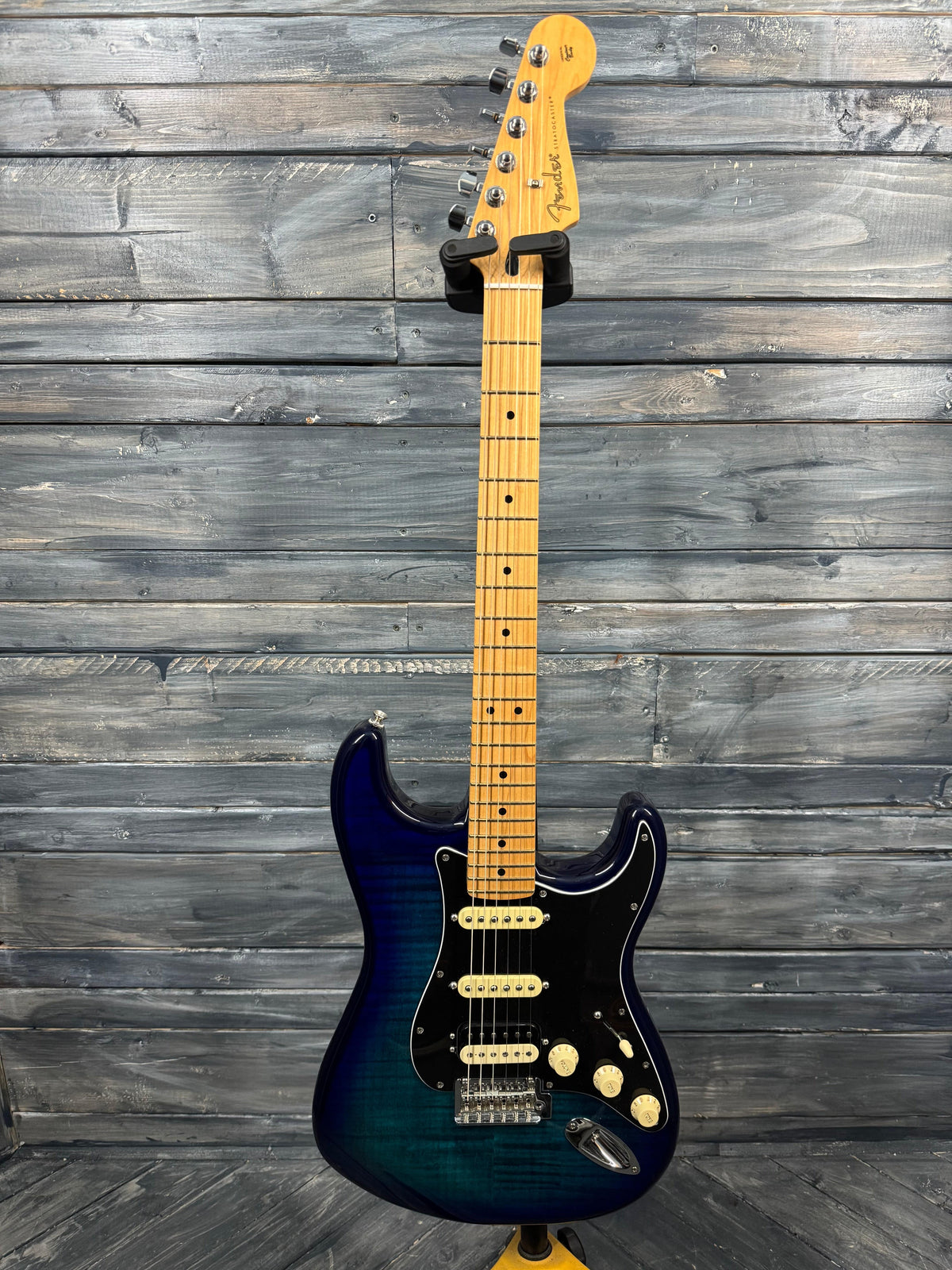 Electric guitar with a blue and black finish against a wooden background
