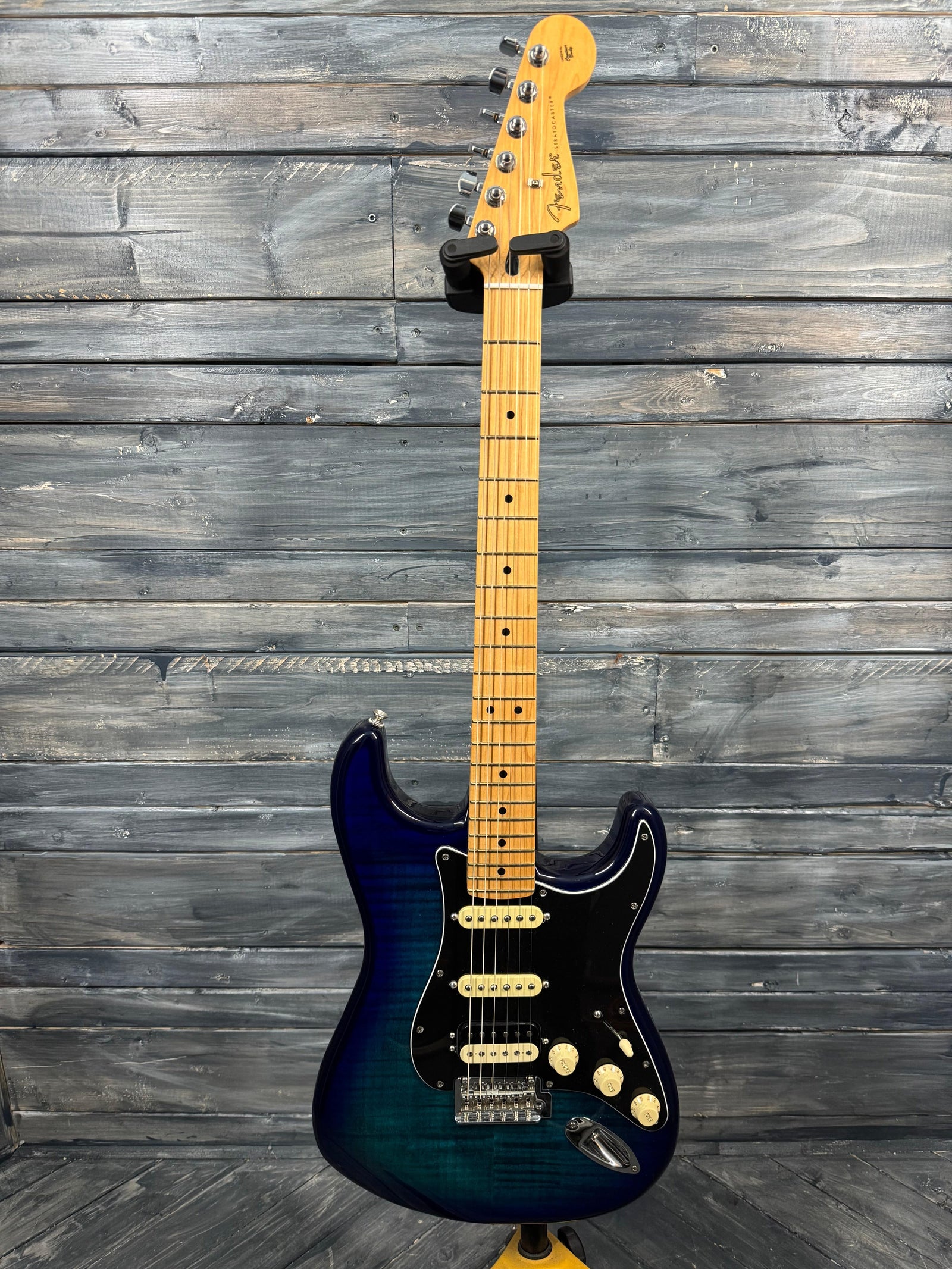 Electric guitar with a blue and black finish against a wooden background