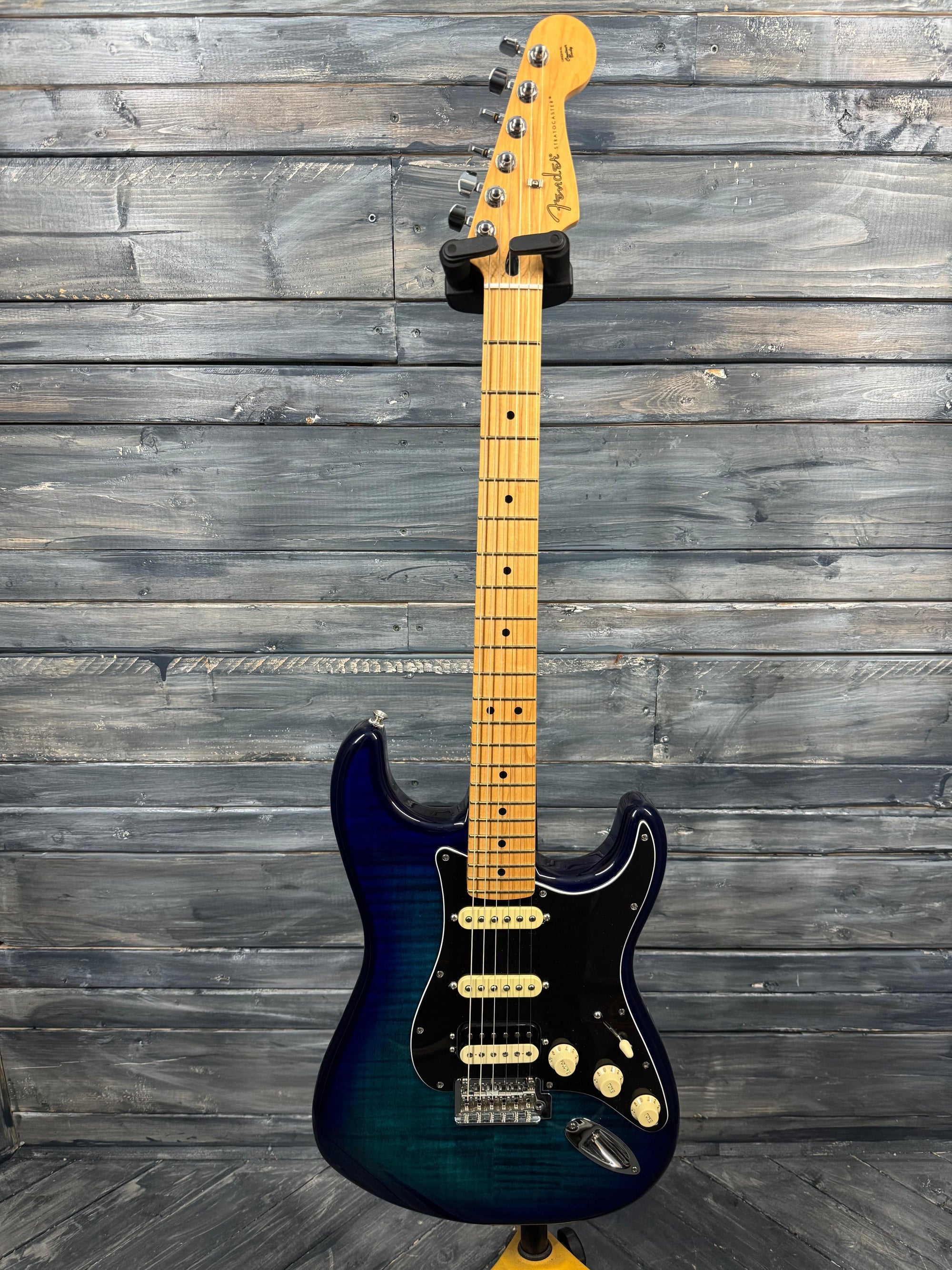 Electric guitar with a blue and black finish against a wooden background