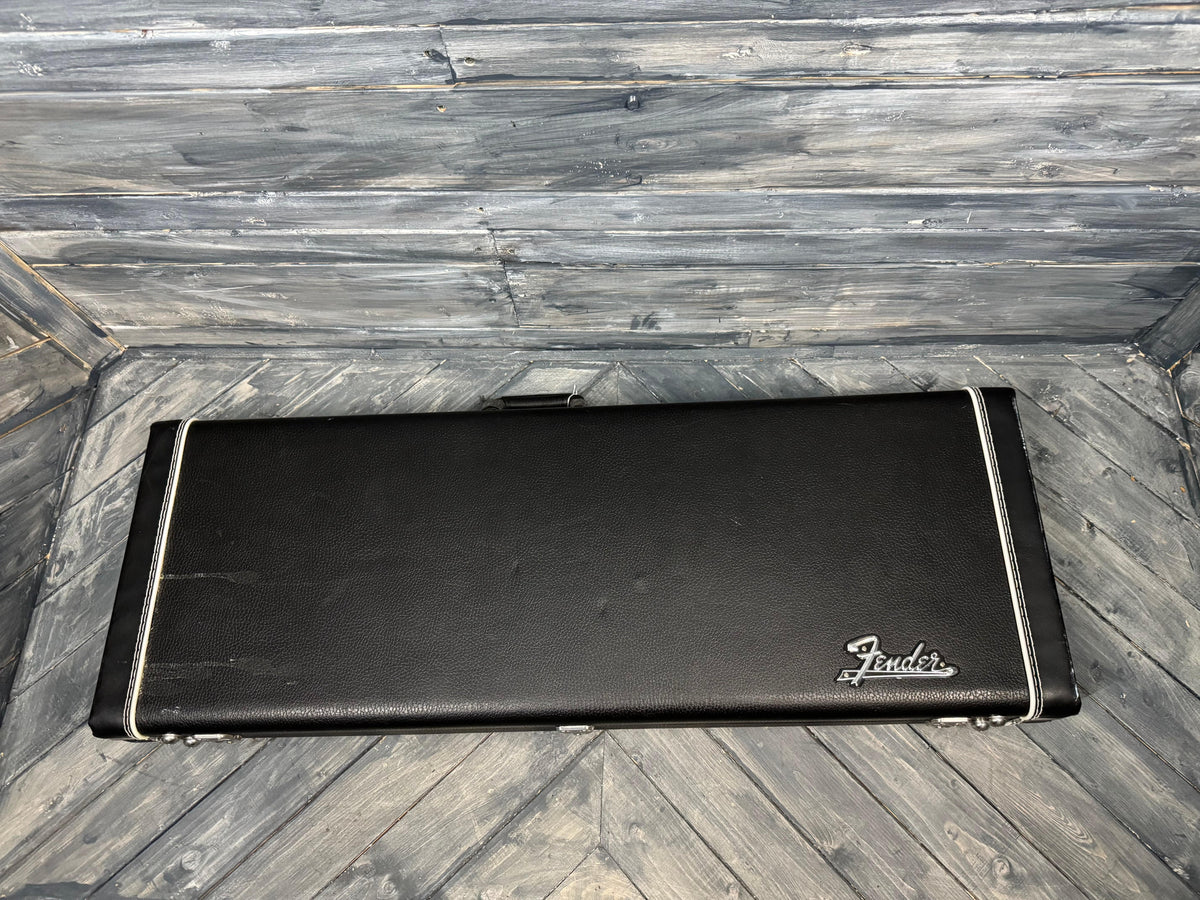 Black Fender guitar case on a wooden floor