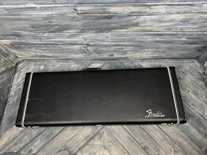 Black Fender guitar case on a wooden floor