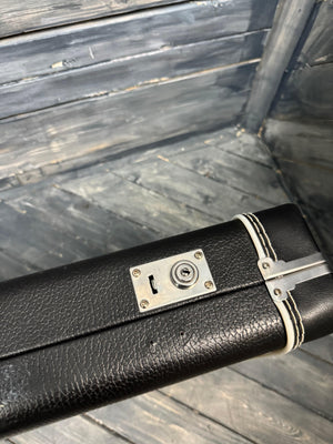 Black pool cue case with silver hardware on a wooden background