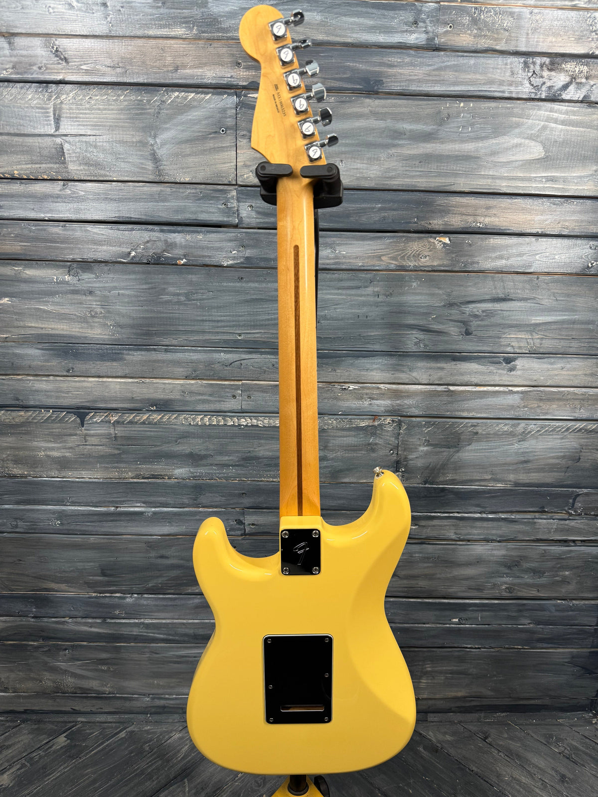 Yellow electric guitar against a wooden background