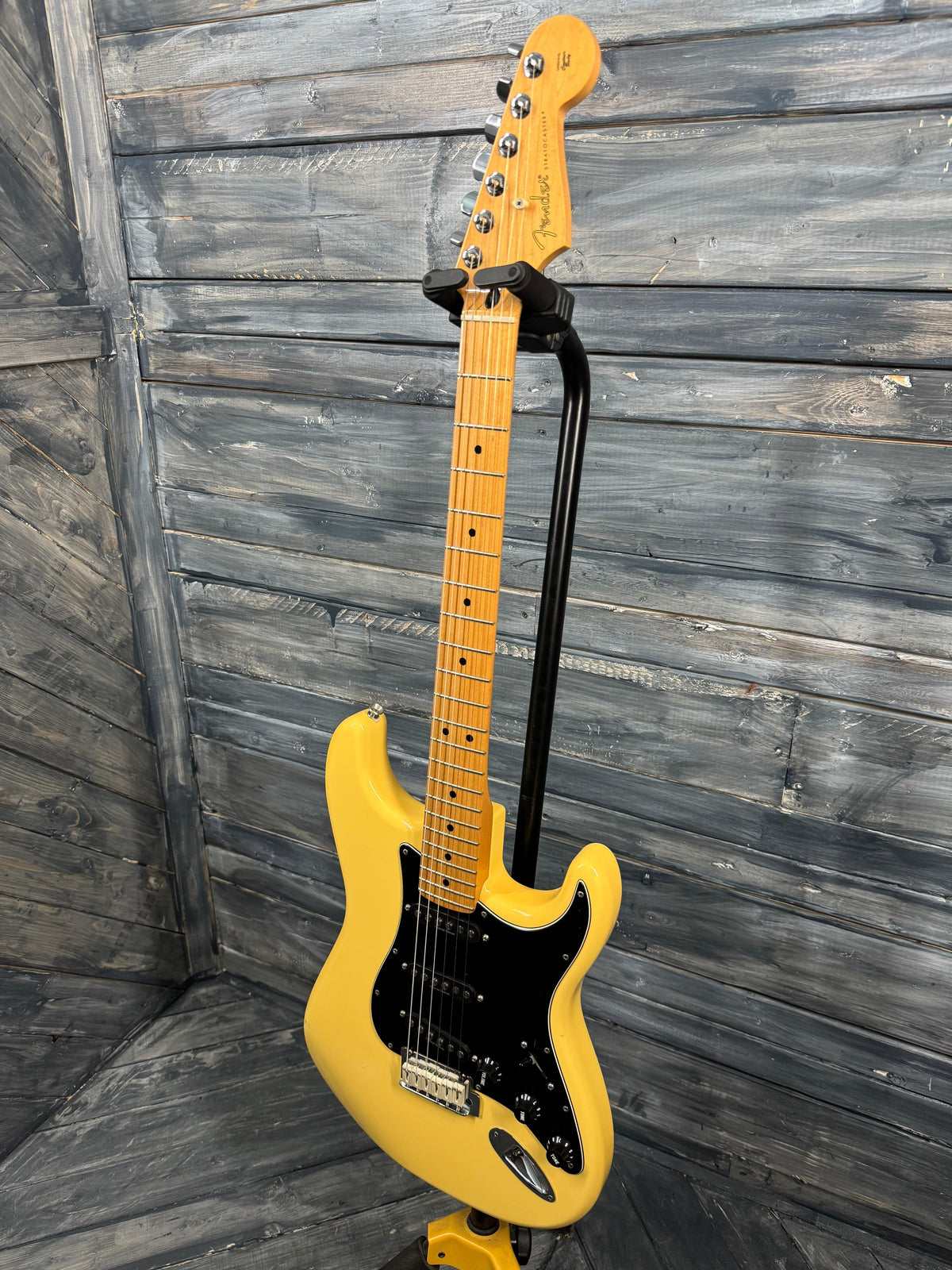 Yellow electric guitar against a wooden background
