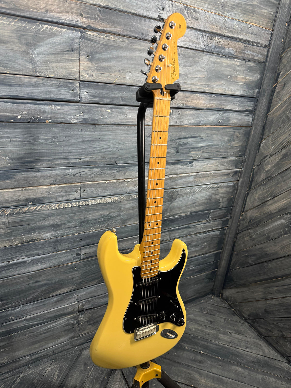 Yellow electric guitar on a wooden floor