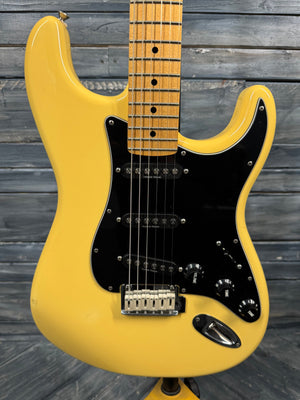 Yellow electric guitar on a wooden background