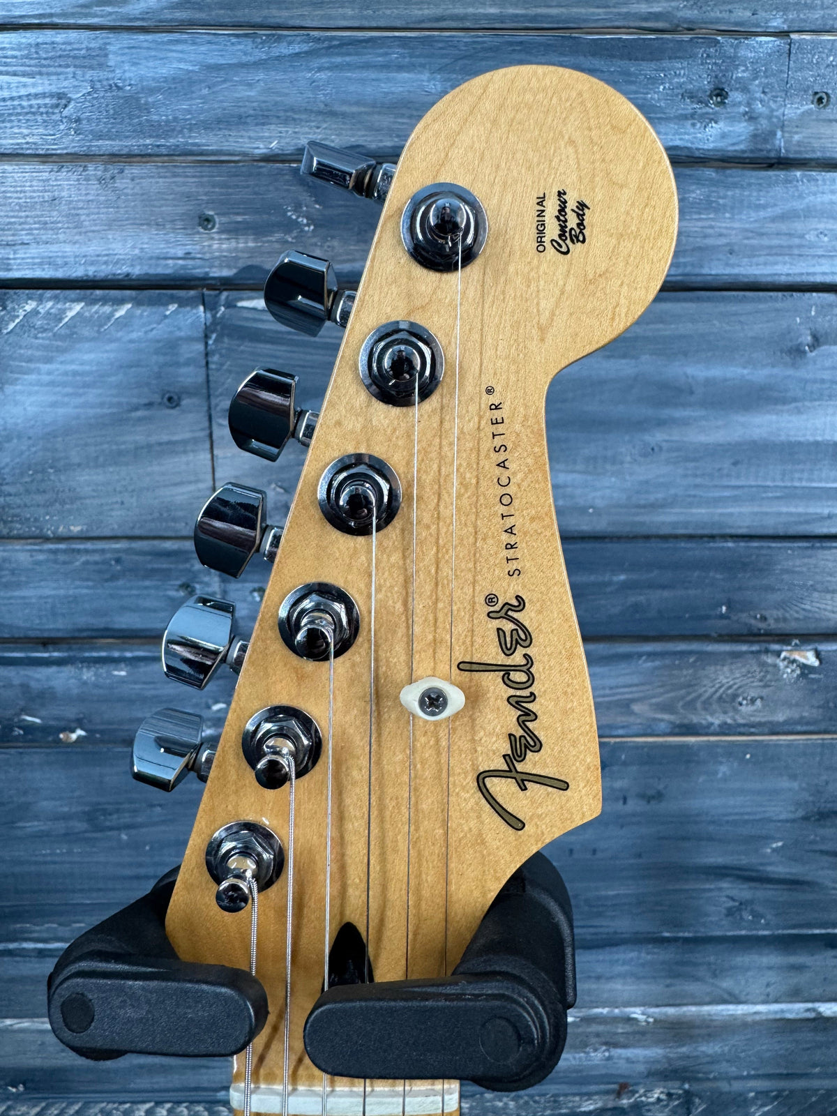 Fender Stratocaster guitar headstock on a wooden background