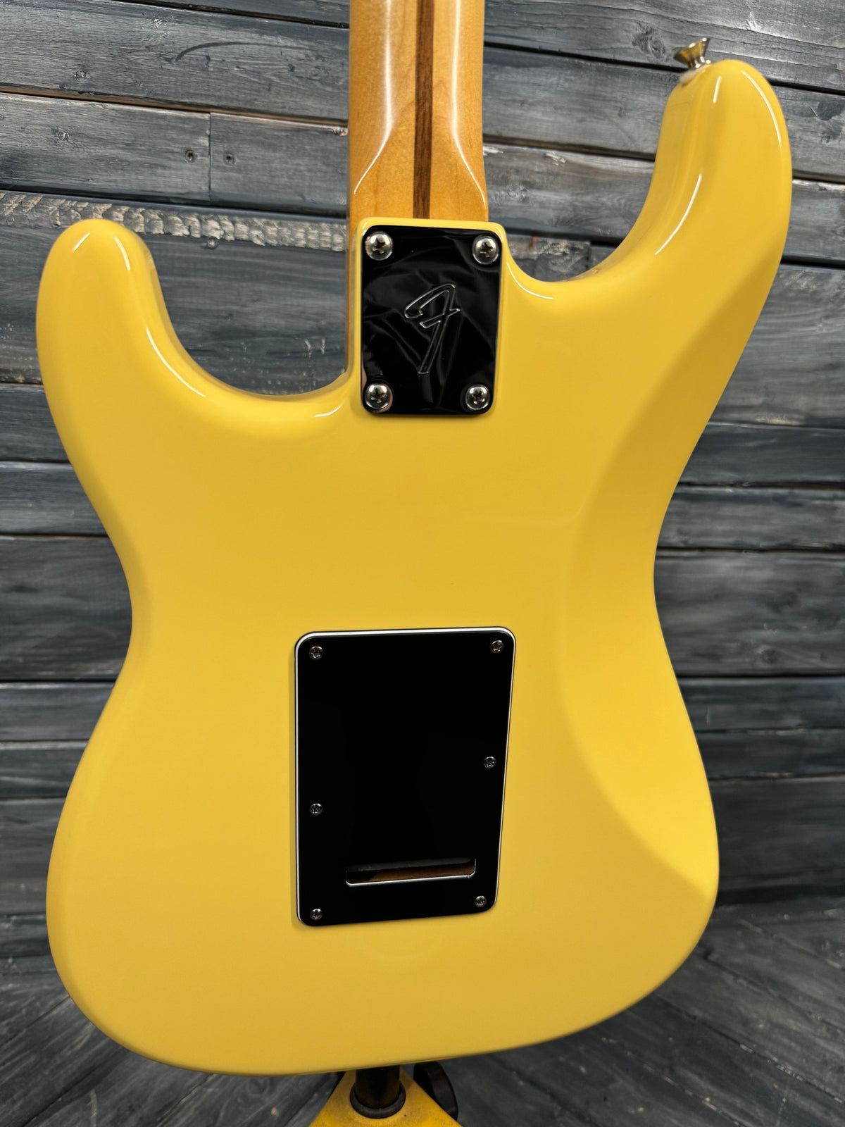 Yellow electric guitar body on a wooden surface
