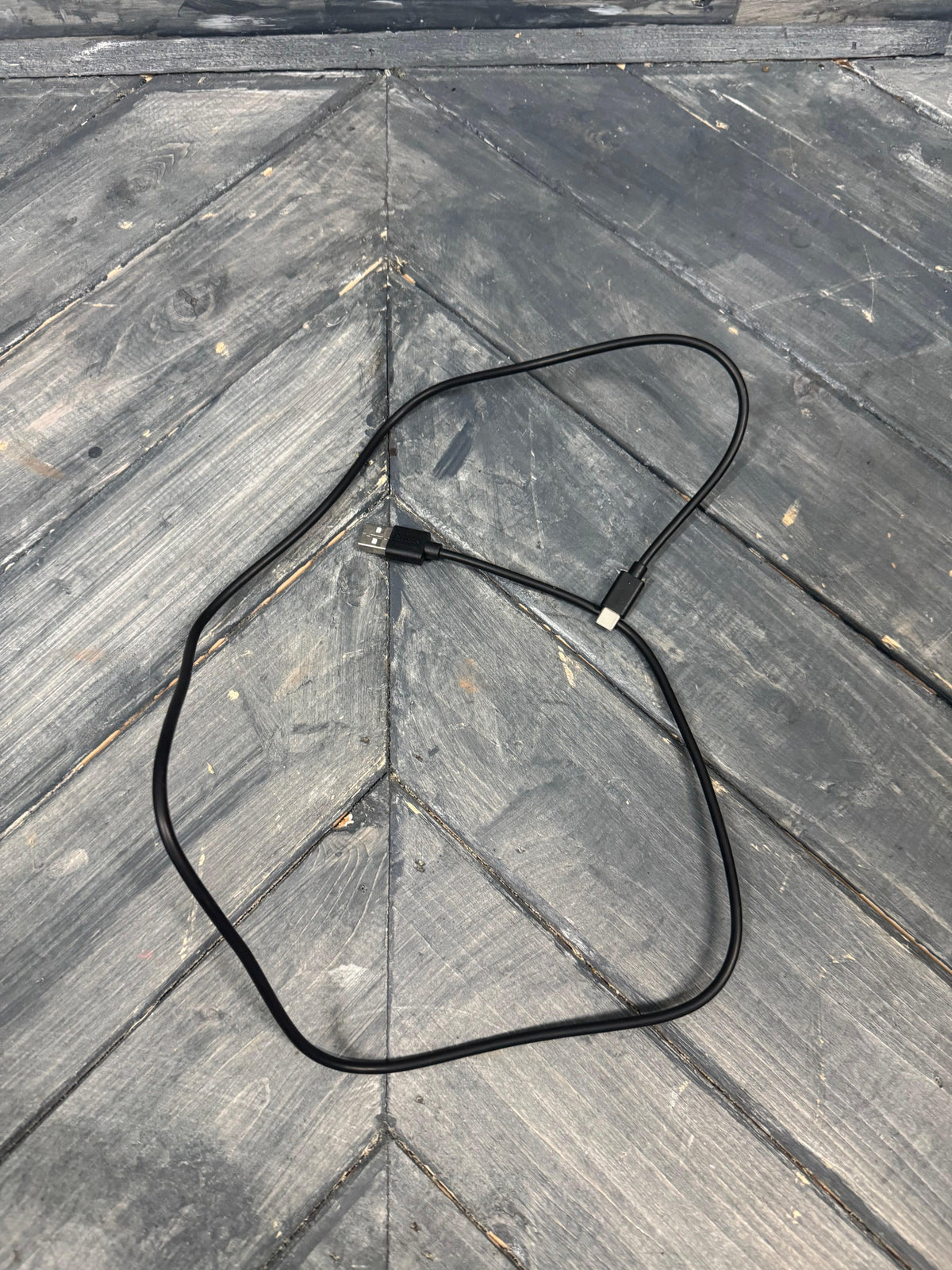 Black cable on a wooden surface