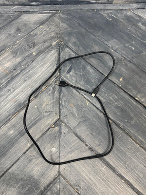 Black cable on a wooden surface