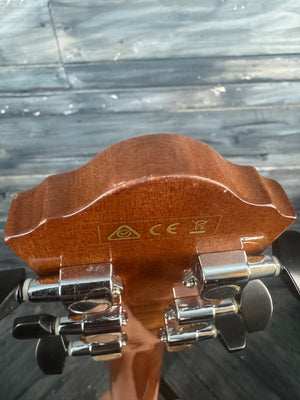 Close-up of a guitar headstock with tuning pegs against a wooden background