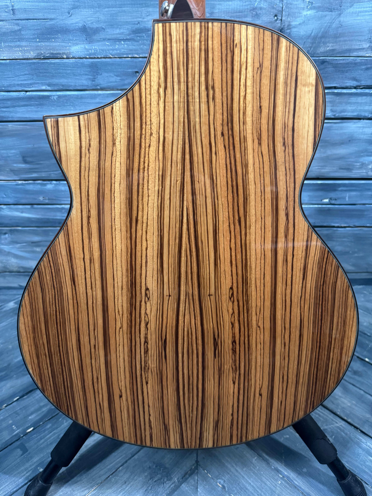 Wooden guitar body with zebrawood pattern on a wooden surface