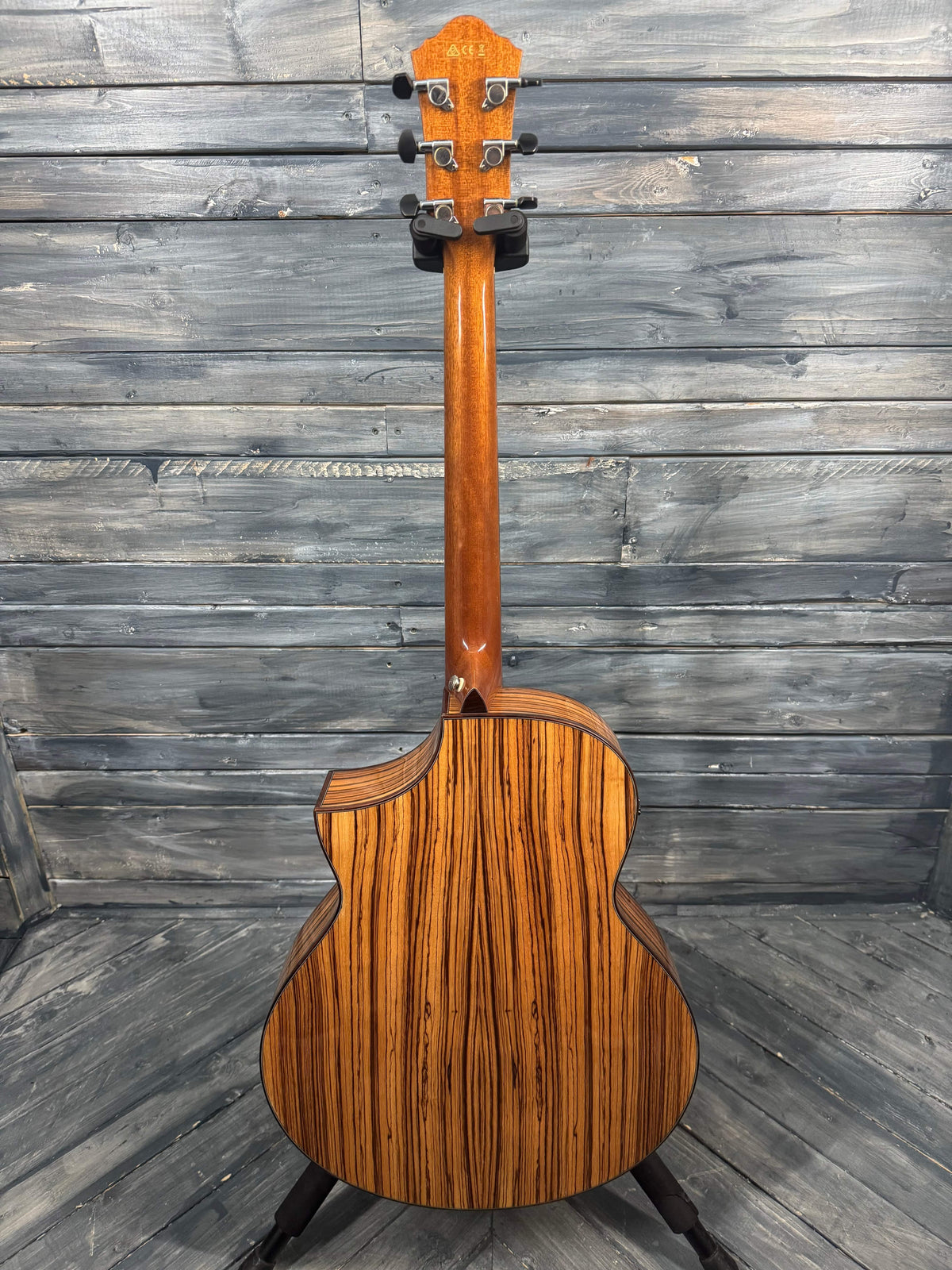 Wooden acoustic guitar against a wooden panel background
