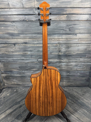 Wooden acoustic guitar against a wooden panel background