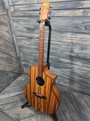 Wooden acoustic guitar leaning against a wooden wall.