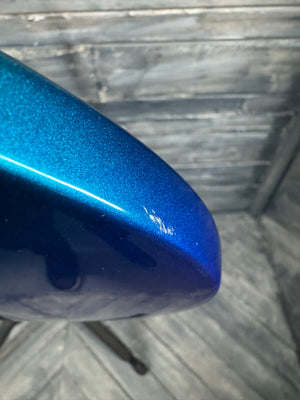 Close-up of a blue metallic object on a textured surface