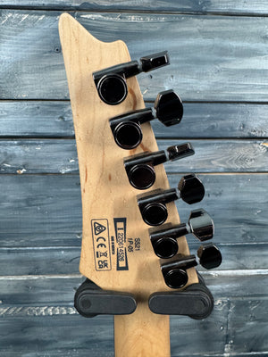 Guitar headstock with tuning pegs on a wooden surface