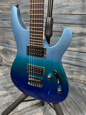 Blue electric guitar on a stand against a wooden background