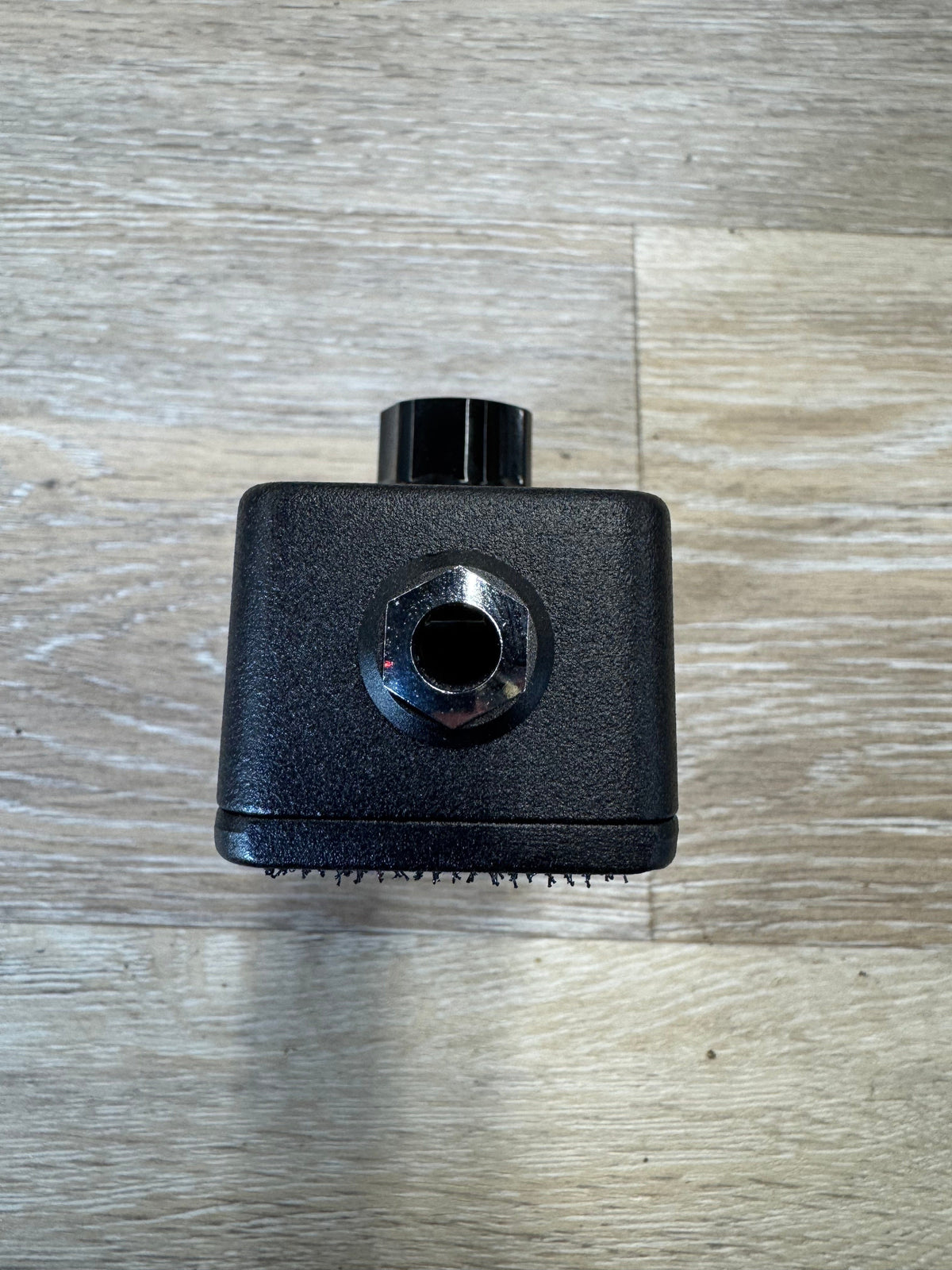 Black mechanical component on a wooden surface