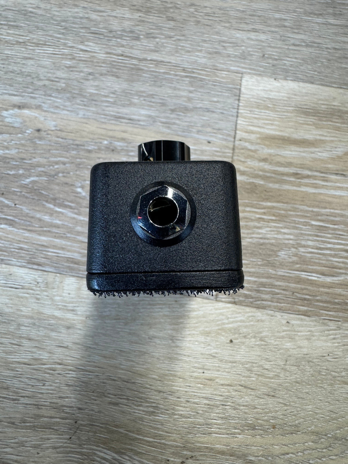 Black brush attachment on a wooden surface