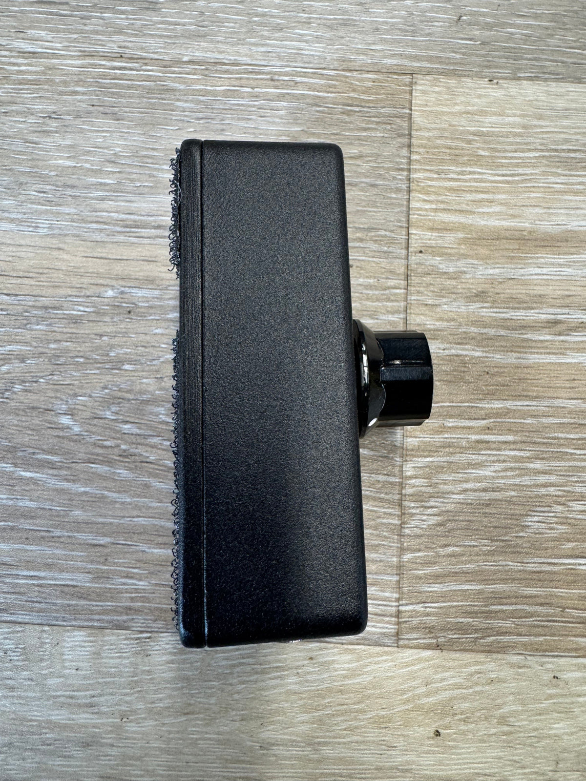 Black scrubber brush on a wooden floor