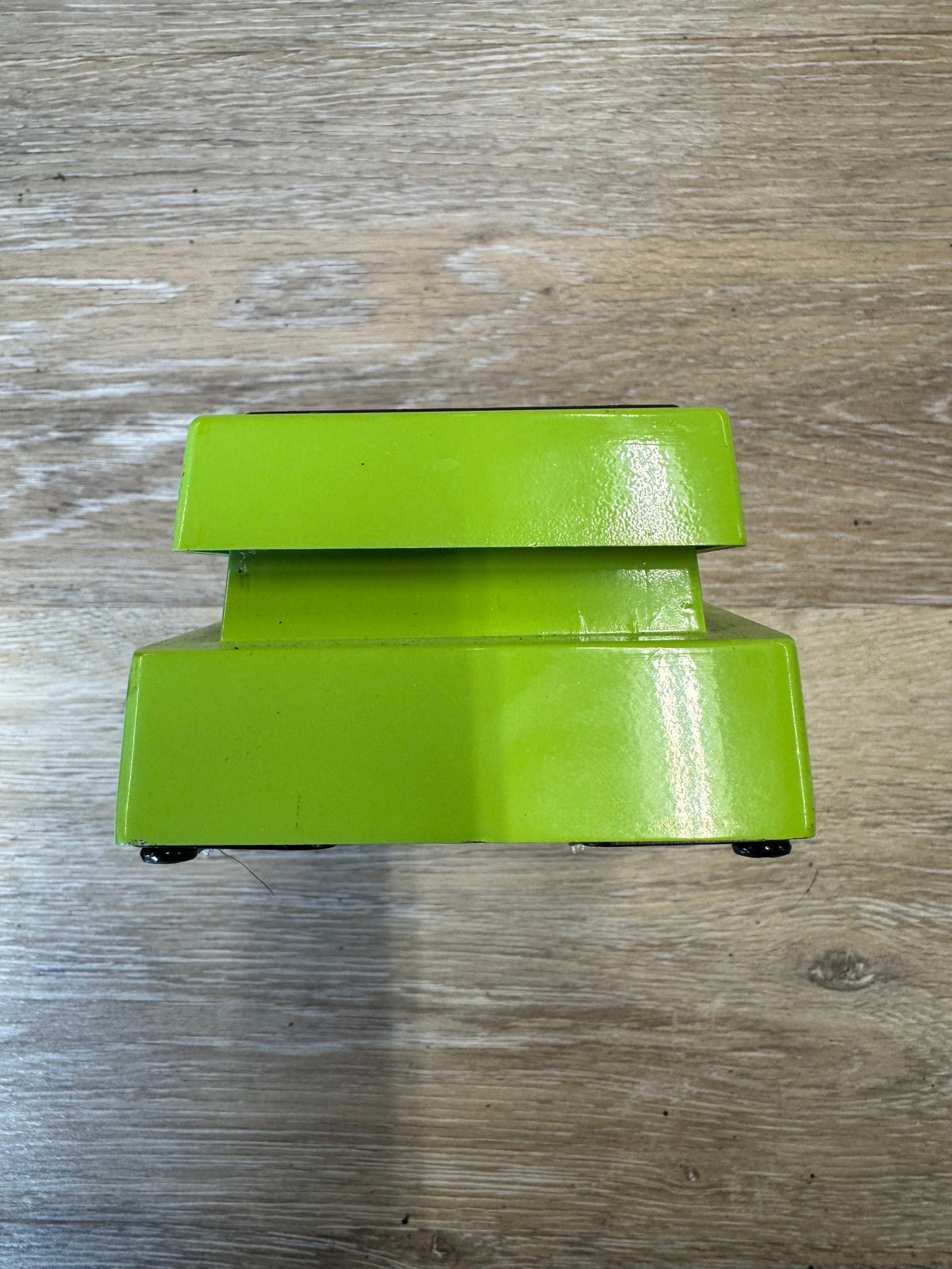 Green metal bracket on a wooden surface