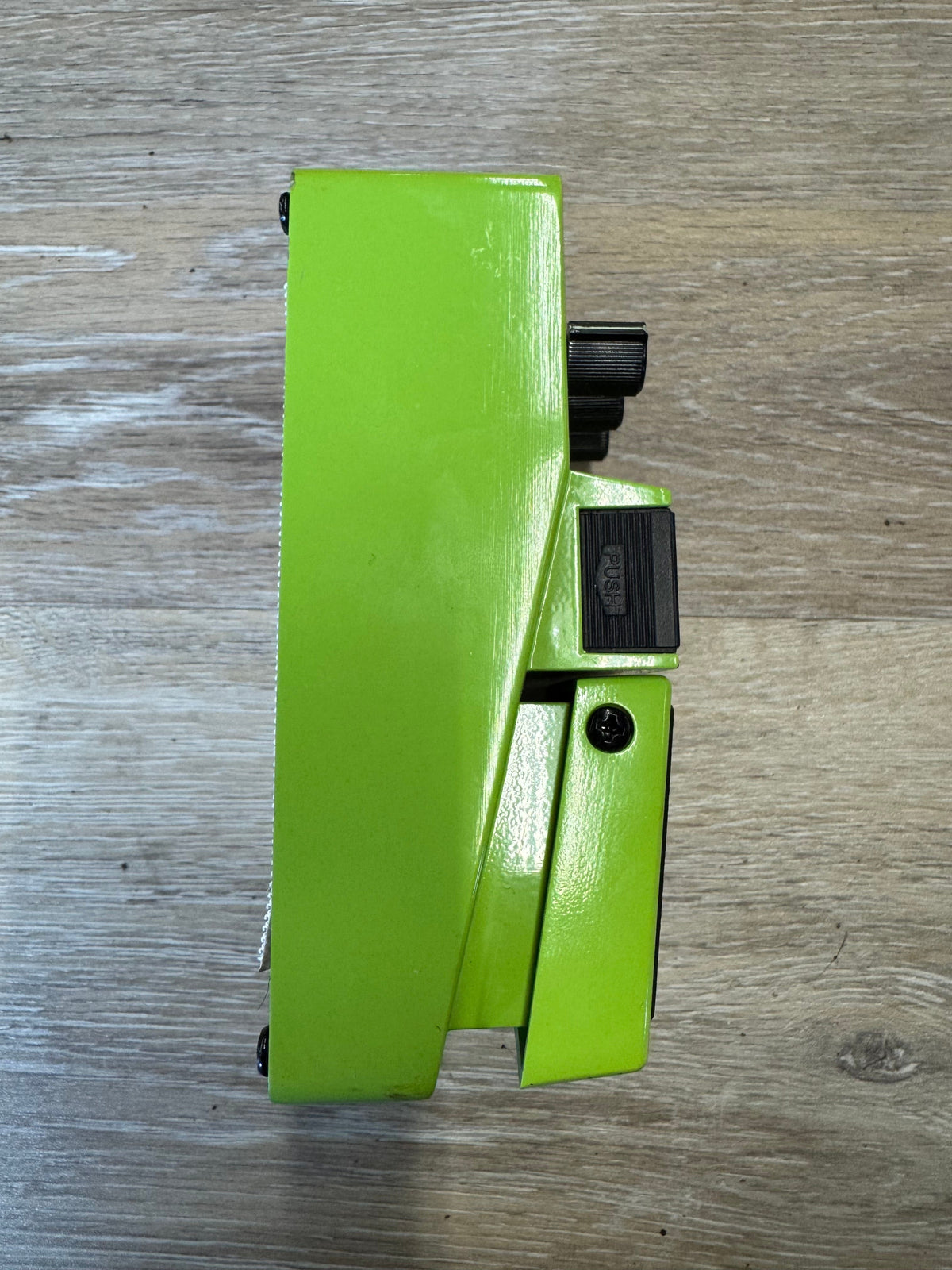 Green metal bracket on a wooden surface