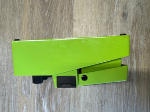 Green office stapler on a wooden surface