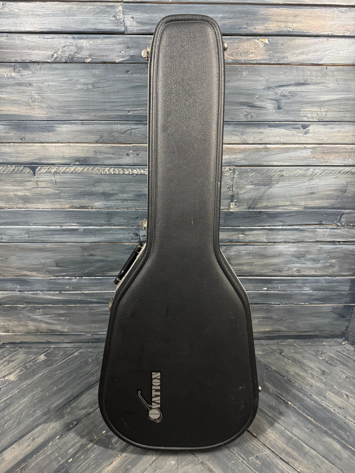 Black guitar case with a brand logo on a wooden surface